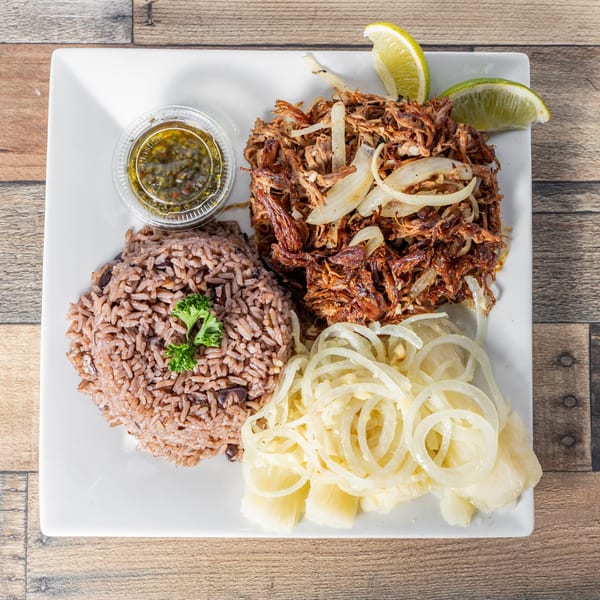 Cuban shredded beef with onions, rice and beans, yucca, and a side of green sauce.